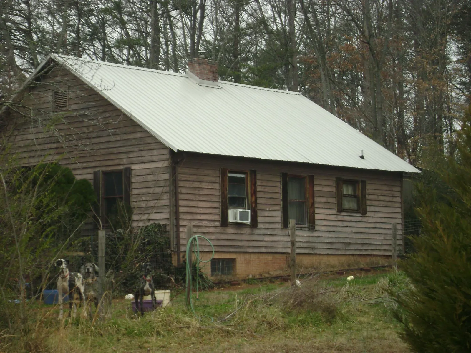 White metal roof on an old wood sided farmhouse, from a Metal Roof Installation job in Johnson